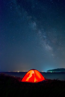 turistler Gölü kıyısındaki Sevan Samanyolu altında Tarih ile turuncu çadır