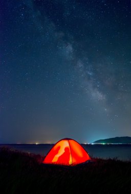 orange tent with tourists on the shore of Lake Sevan under the Milky Way clipart