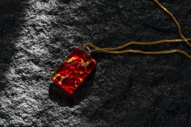 Altın zincir bir siyah granit yüzey ile kırmızı kolye