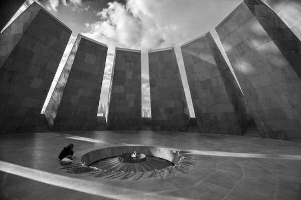 a girl mourns at Eternal flame at the Tsitsernakaberd memorial monument of the Armenian Genocide, Yerevan, Armenia. On 24th of April, 1915, 1.5 million civilian Armenians were killed by Ottoman Empire