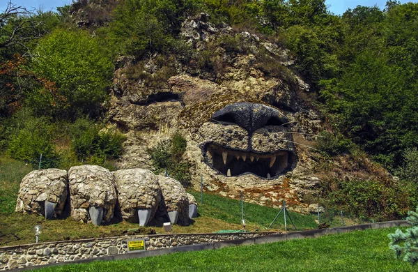 Roaring sculpture of a lion on a rocky hill, Vank, Nagorno-Karabakh Republic. Inscription in Russian says: "Caution Angry lion Not tease"  It roars when you approach. — Stock Photo, Image
