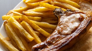 Biftek ve cips, pastırma domuz beyaz tabak patates kızartması ile