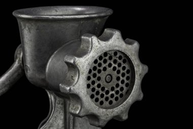 Eski manuel kıyma makinesinin yakın görüntüsü. Siyah arkaplanda izole