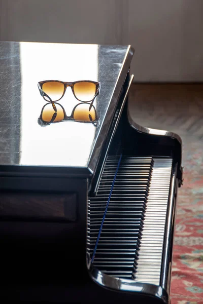 Abstrakcyjna Scena Okularami Przeciwsłonecznymi Refleksją Nad Klasycznym Fortepianem Oświetlonym Porannym — Zdjęcie stockowe