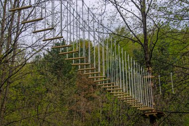 İp parkı ekipmanlarının bakış açısı. Halat parkında kayışlar, arka planda yeşil ağaçlar