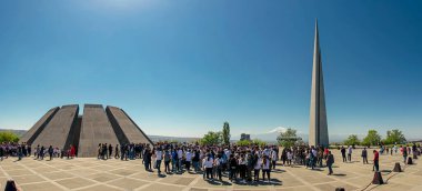Erivan, Ermenistan - 24 Nisan 2021: Ararat Dağı 'nın arka planında Ermeni Soykırımı Anıtı' nın yakınındaki insanlar. Büyük bir manzara, mavi gökyüzü, güneşli bir gün.