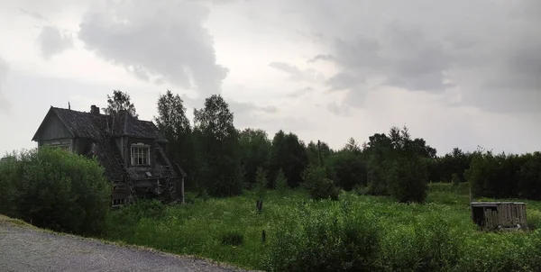 在一个乡村的夏天 一座巨大美丽的两层木结构的废弃农舍 带有剥落的油漆和破碎的窗户 — 图库照片