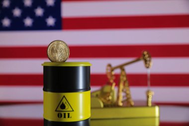 Amerika Birleşik Devletleri bayrağının arka planında altın sikke olan petrol varili.