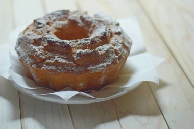 Ev yapımı kek şeklinde fırınlanmış yiyecekler peçetelerin üzerinde, beyaz bir tabakta, eski beyaz boyalı bir masanın üzerinde duruyor.