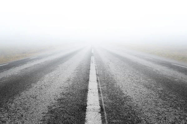 Camino de asfalto con luz en la distancia — Foto de Stock