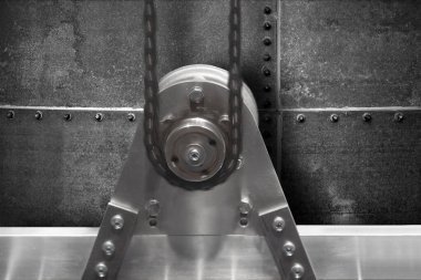 Grunge metal arka planında dönen parçası ve zinciri olan makine