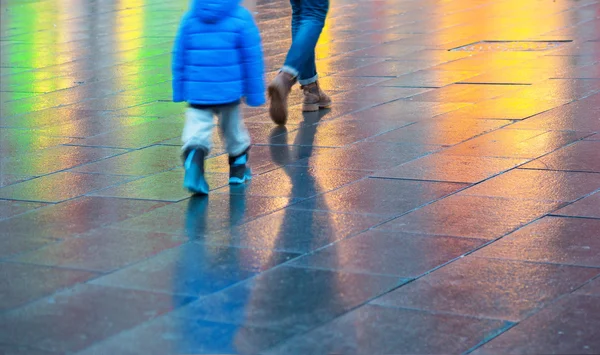 Young boy walking on wet pavement — Stock Photo, Image