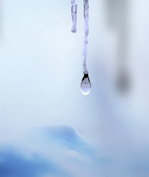 Icicle with drop of water on blue, — Stock Photo, Image