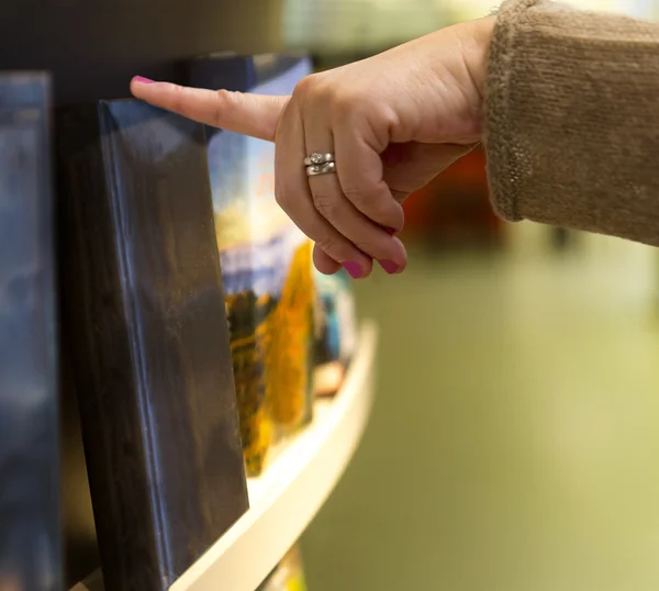 Hand of woman picking book — Stock Photo, Image