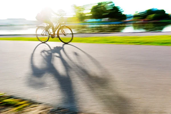 Person on bike casting shadow — Stock Photo, Image