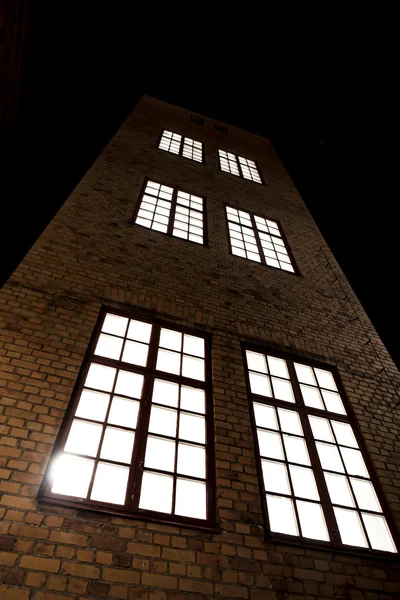 レンガの壁と大きな窓の背の高い建物 — ストック写真