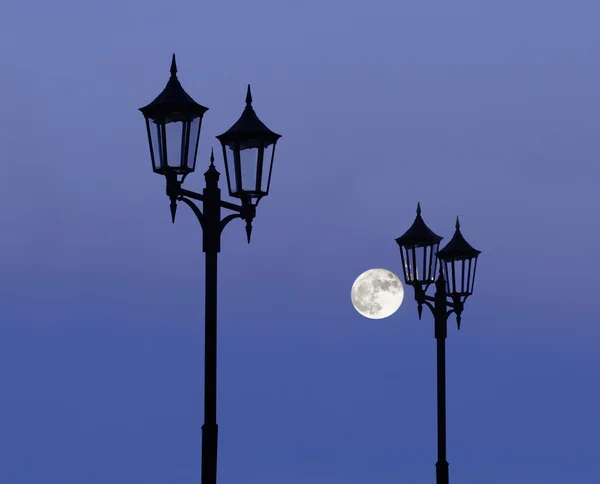 Lampan inlägg på lila sky med fullmåne — Stockfoto