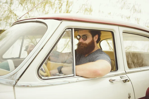 Homem barbudo ao volante de um carro retro — Fotografia de Stock
