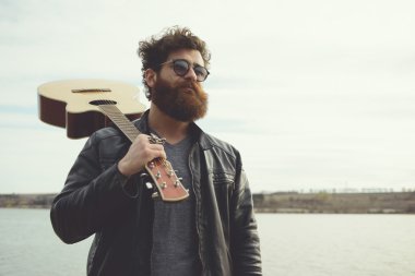 Sakallı adam açık havada retro car yakınındaki gitar çalmak