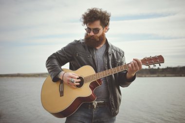 Sakallı adam açık havada retro car yakınındaki gitar çalmak