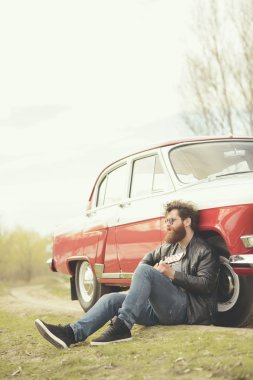 Sakallı adam açık havada retro car yakınındaki gitar çalmak