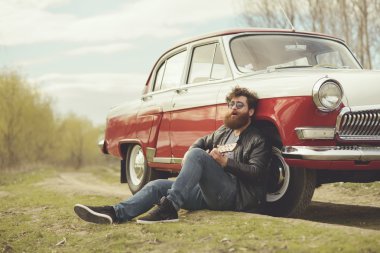 Sakallı adam açık havada retro car yakınındaki gitar çalmak