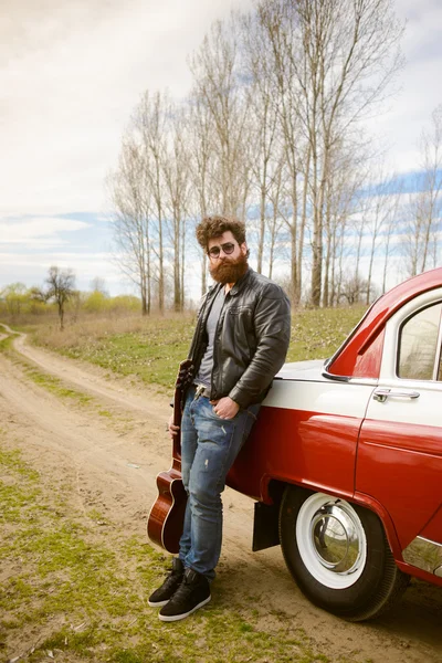 Bärtiger Mann spielt Gitarre im Freien in der Nähe von Retro-Auto — Stockfoto