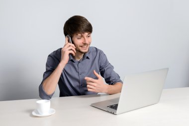 Dizüstü bilgisayarda çalışan genç adam.