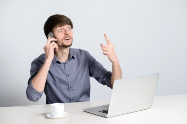 Dizüstü bilgisayarda çalışan genç adam.