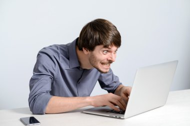 Dizüstü bilgisayarda çalışan genç adam.