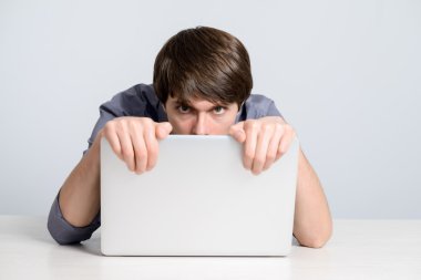 Dizüstü bilgisayarda çalışan genç adam.