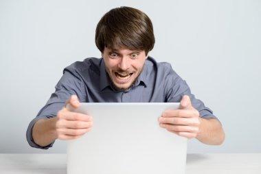 Dizüstü bilgisayarda çalışan genç adam.