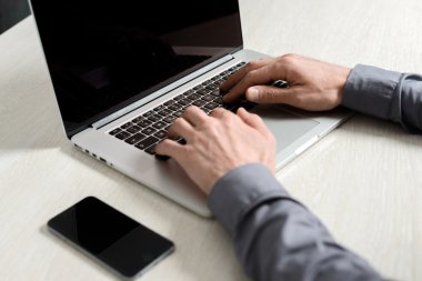 Dizüstü bilgisayarda çalışan genç adam.