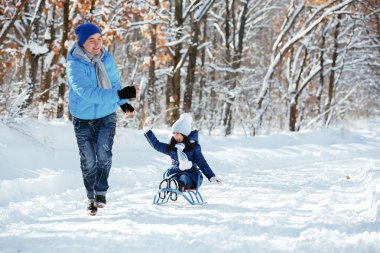 Baba ve kışın karda oynayan kız