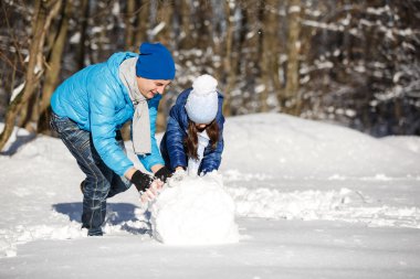 Baba ve kışın karda oynayan kız