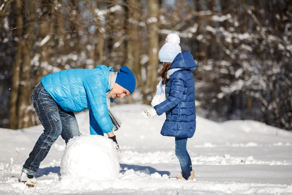 Κοριτσάκι παίζει με έναν χιονάνθρωπο — Φωτογραφία Αρχείου