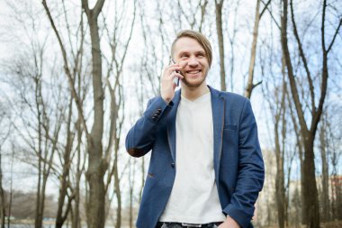 mutlu bir adam cep telefonuna konuşuyor