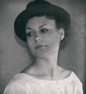 Şapkalı zarif bir kadının siyah beyaz portresi.