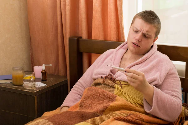 Άρρωστος Θερμόμετρο Και Μπουρνούζι Ξαπλωμένος Στο Κρεβάτι — Φωτογραφία Αρχείου