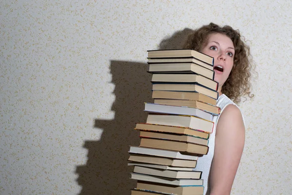 Curly Menina Segurando Uma Enorme Pilha Livros — Fotografia de Stock