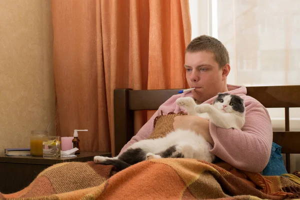Άρρωστος Θερμόμετρο Ξαπλωμένος Στο Κρεβάτι Και Κρατώντας Μια Γάτα — Φωτογραφία Αρχείου