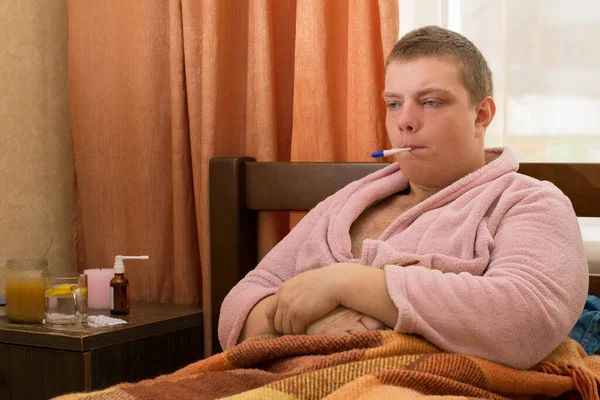 Yatağında Bornozlu Termometresi Olan Hasta Bir Adam — Stok fotoğraf
