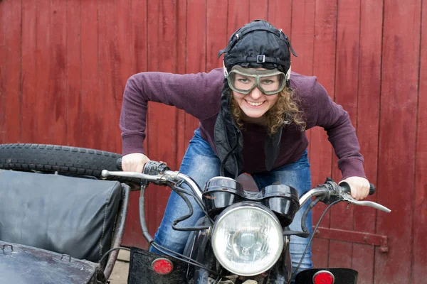 Photo of girl on vintage motorbike in pilot cap