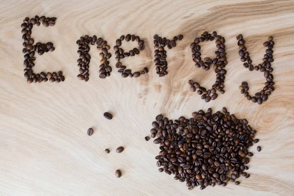 木製の背景にコーヒー粒から出てくる言葉のエネルギー — ストック写真