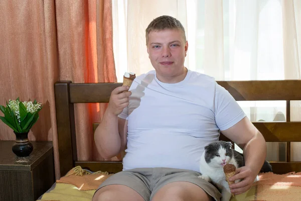 Muž Kočka Jedí Zmrzlinu Posteli — Stock fotografie