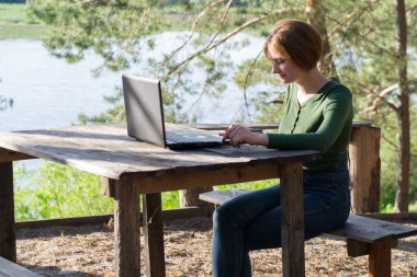 Güzel kız açık havada grafik tabletini kullanıyor.