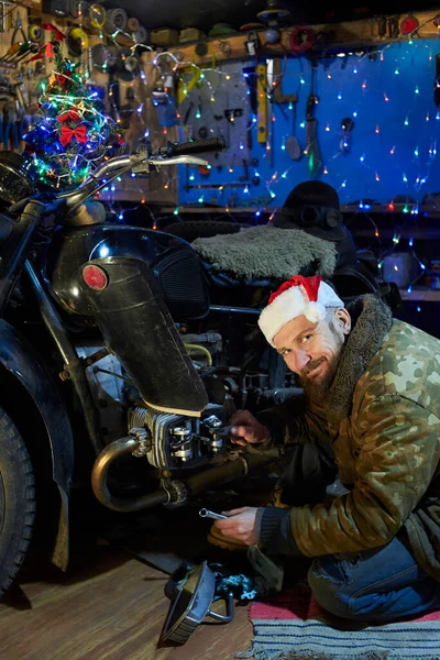 Homme Chapeau Père Noël Répare Une Vieille Moto Dans Garage — Photo