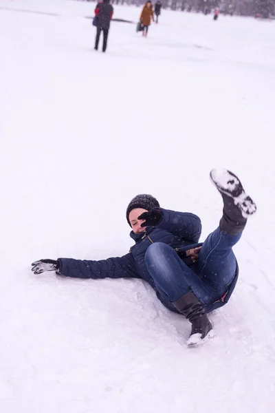 这个女孩在街上滑倒在被雪覆盖的冰上 冬天又跌又跌 — 图库照片