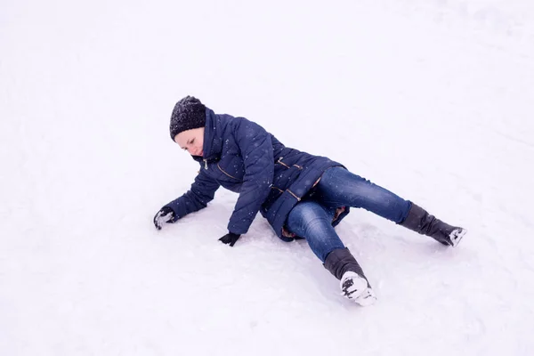 这个女孩在街上滑倒在被雪覆盖的冰上 冬天又跌又跌 — 图库照片