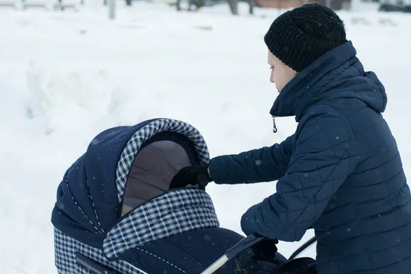 Een Jonge Moeder Loopt Met Een Wandelwagen Een Besneeuwde Winterdag — Stockfoto